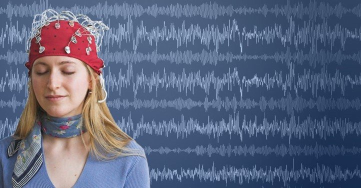 Persona con sensores de actividad cerebral frente a un fondo de ondas cerebrales.